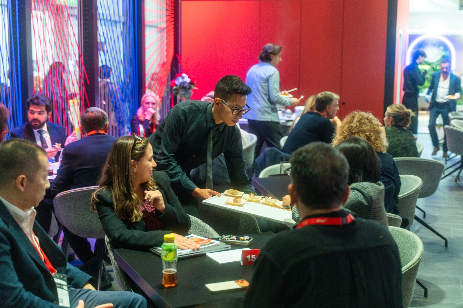 Cameriere che serve finger food a ospiti e professionisti durante un evento fieristico a Milano
